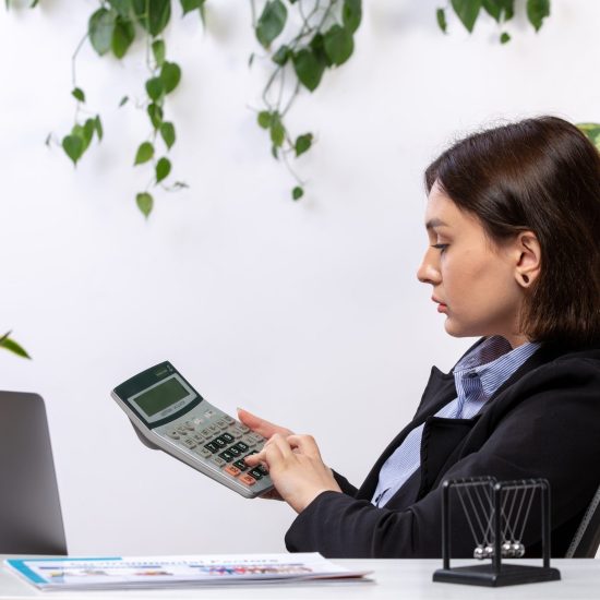 front-view-beautiful-young-businesswoman-black-jacket-blue-shirt-working-with-calculator-front-table-business-job-office